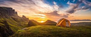 Oranje tent in een berglandschap bij zonsopkomst aan zee